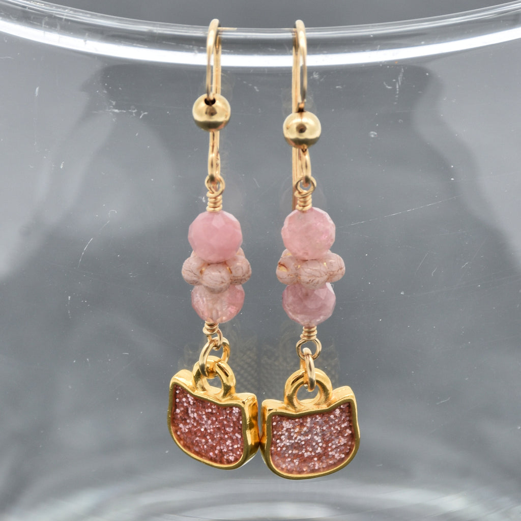 Lovely delicate pink dangle earrings with cat charms, pink tourmaline, and gold ear wires on a glass background - handmade with love by Ruby Acorn