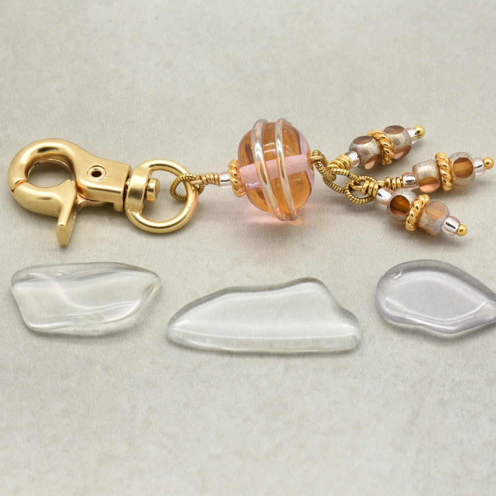 Gold clasp with glass beads on a light gray background