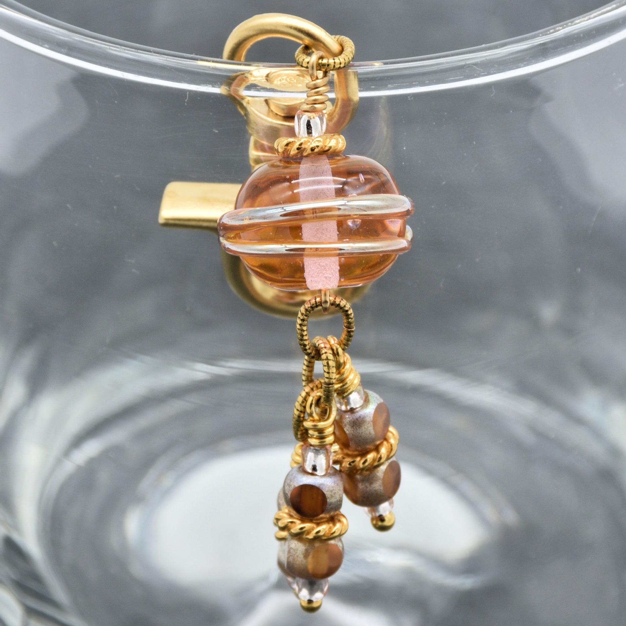 Gold and ivory glass bead keychain on a clear background