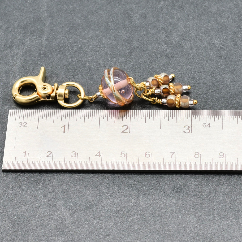 Gold clasp with beads on a ruler for size reference