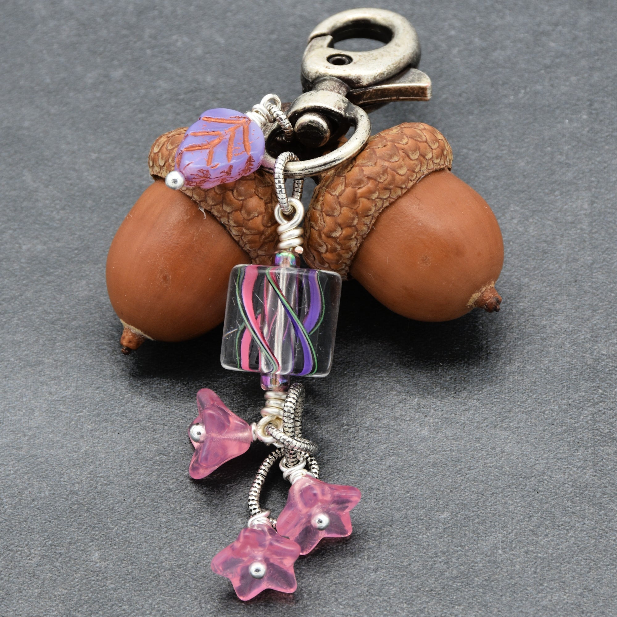 Keychain with pink floral elements on a gray background