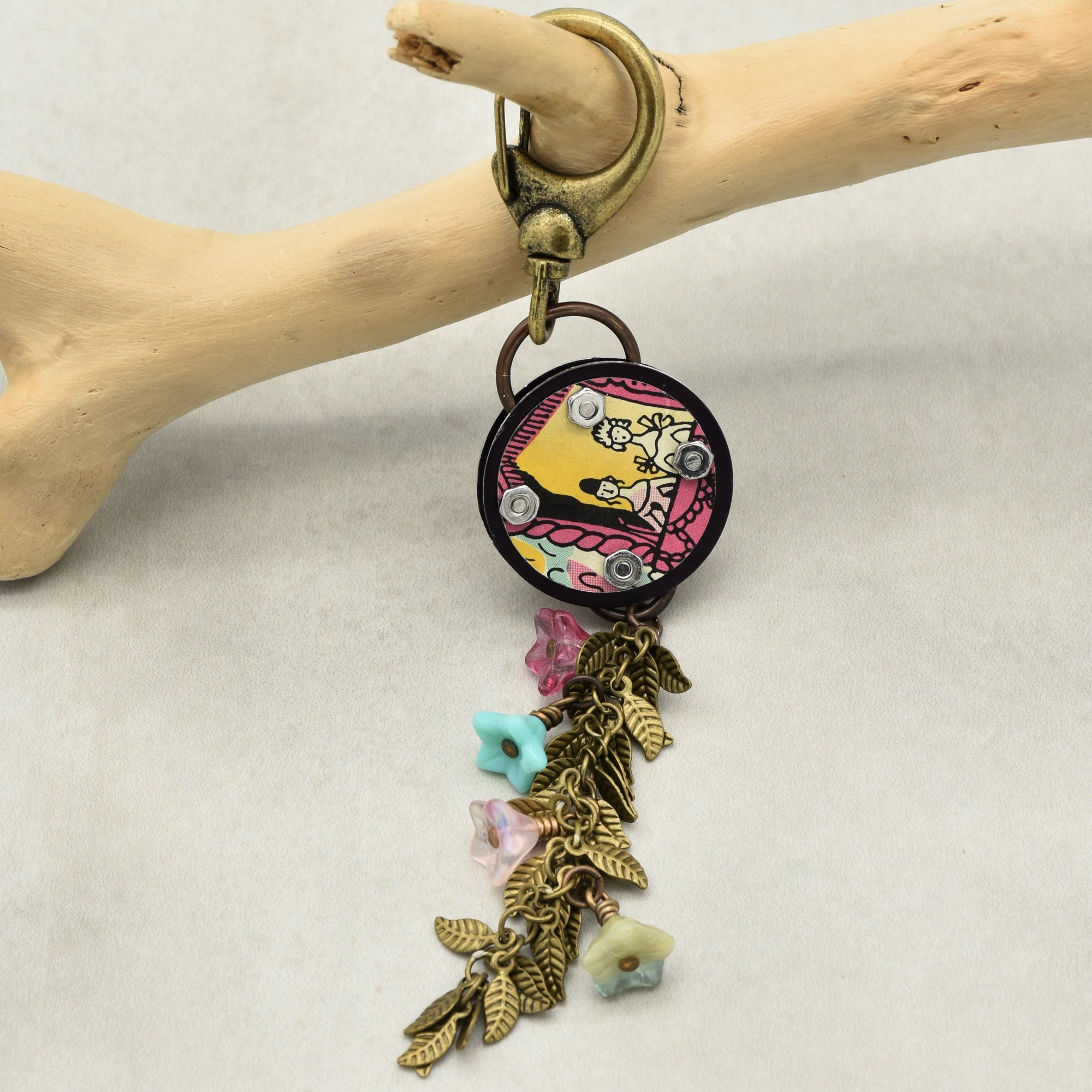 Decorative handbag charm with colorful floral elements on a light background