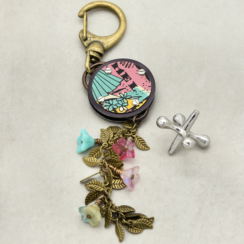 Handbag charm with colorful pendant and charms on a beige background