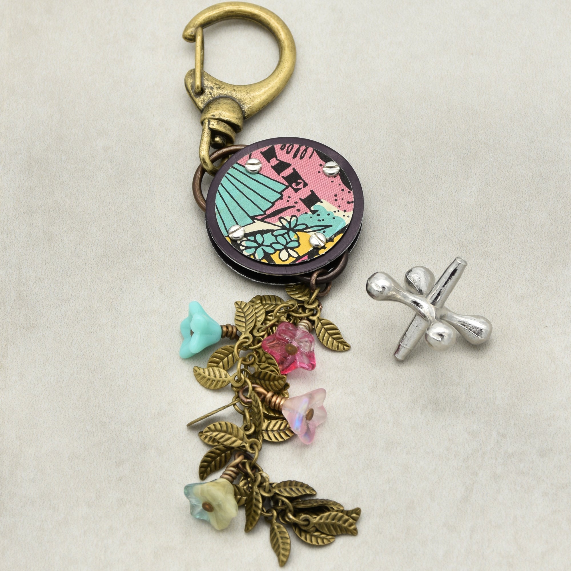 Handbag charm with colorful pendant and charms on a beige background