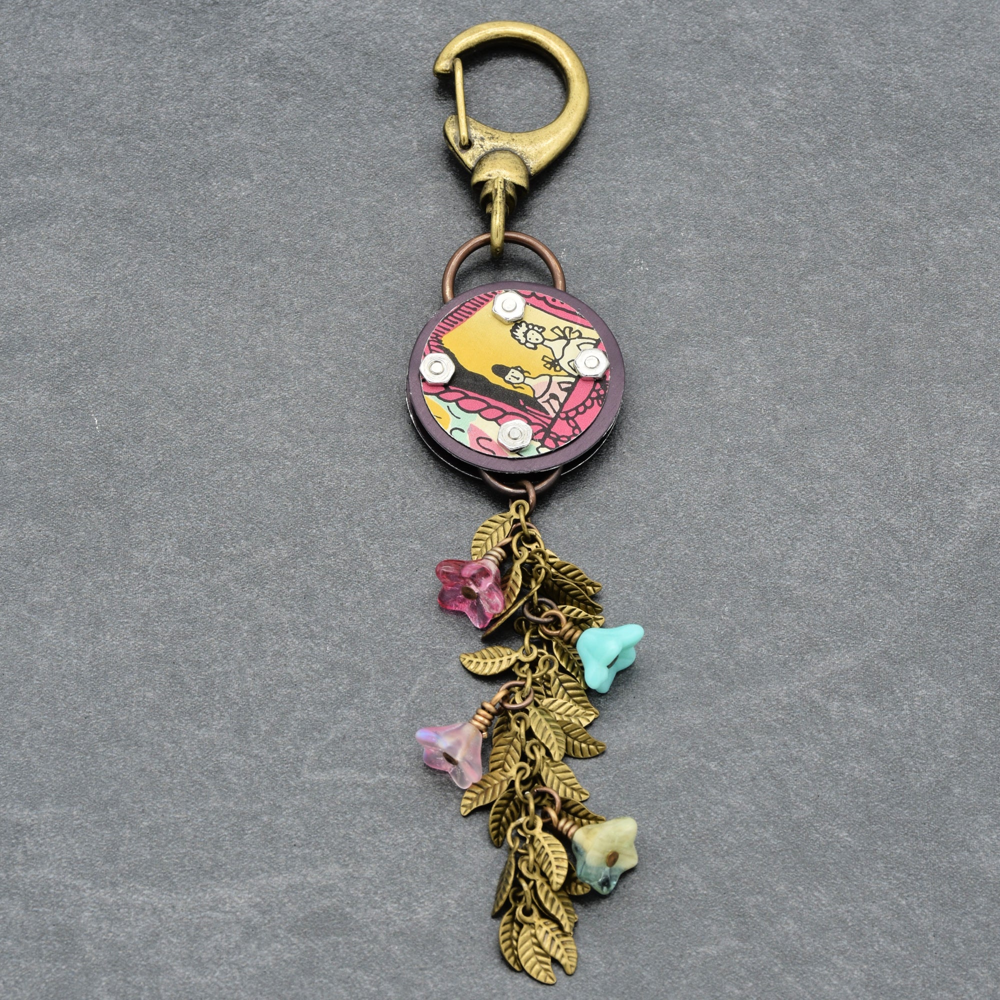 Decorative handbag charm with floral charm on a gray background