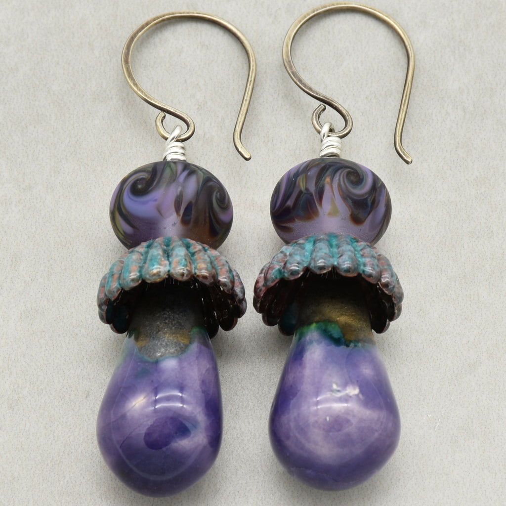 Pair of purple swirl earrings with sterling silver ear wires on a light gray background