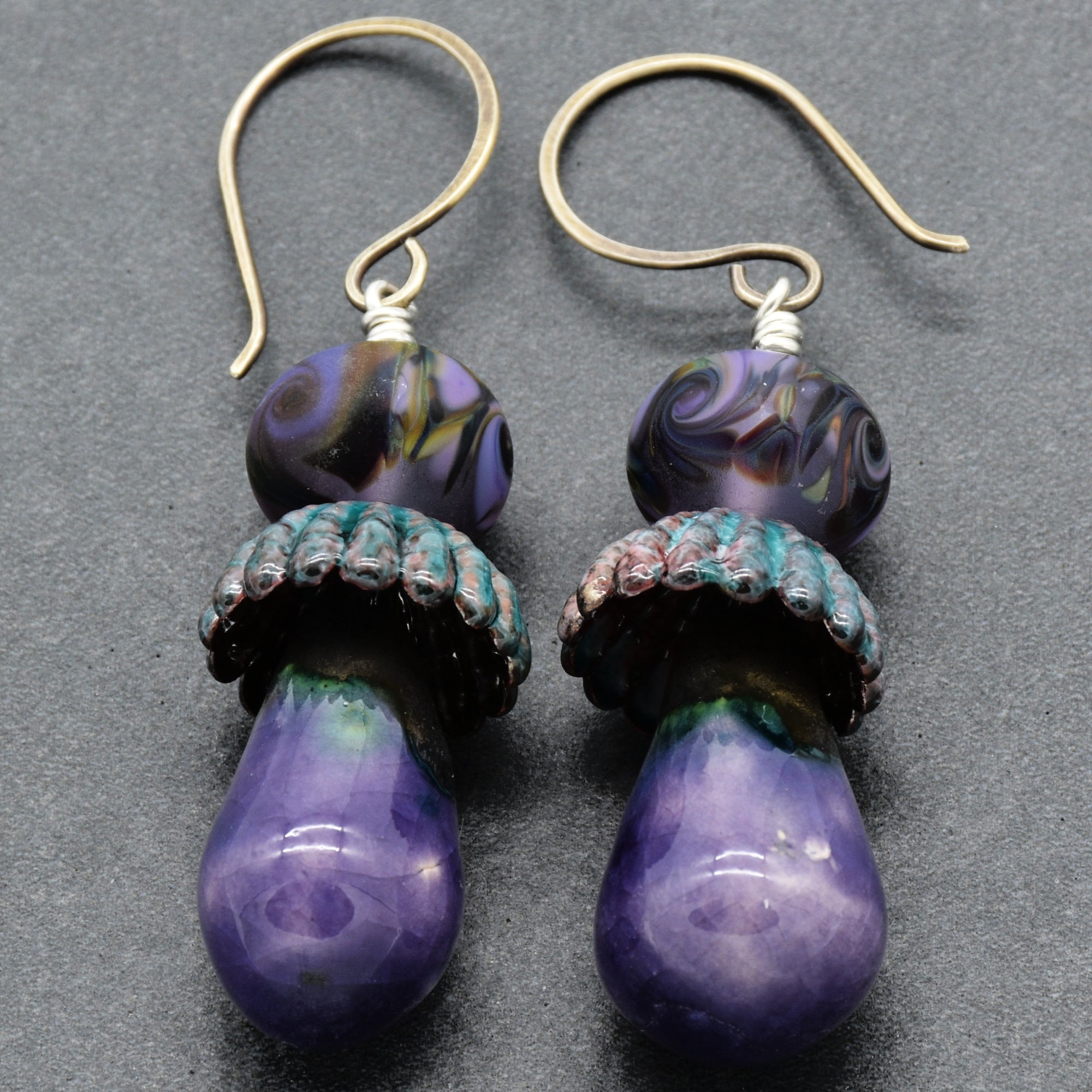 Purple earrings with sterling silver ear wires on a gray background.