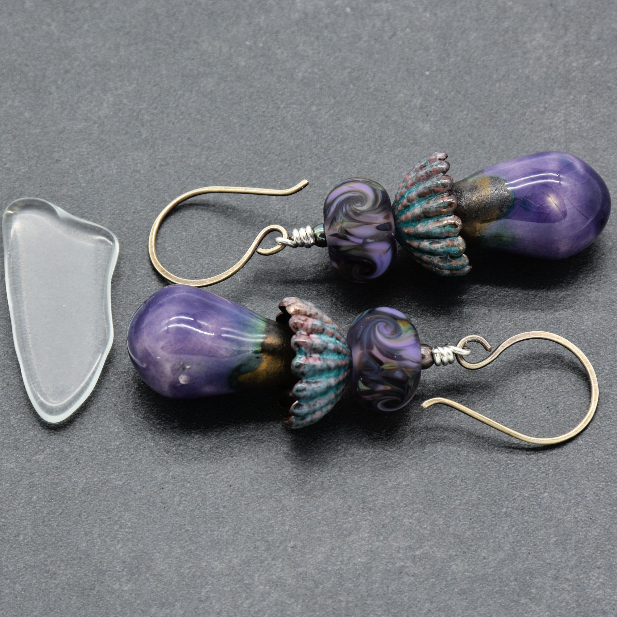Pair of purple earrings on a gray background