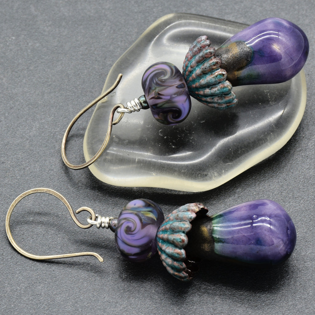 Pair of purple swirl earrings with sterling silver ear wires on a gray surface.