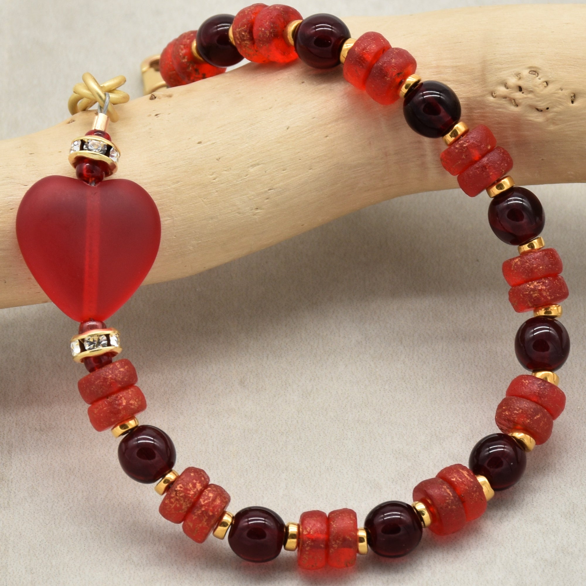 Beaded bracelet with red beads on a wooden branch