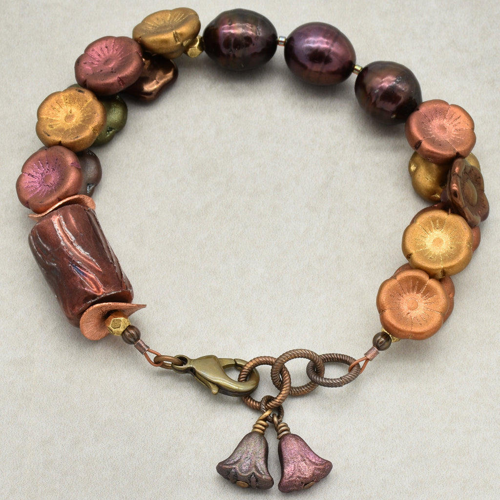 Bracelet with multicolored beads and floral charm on a light background