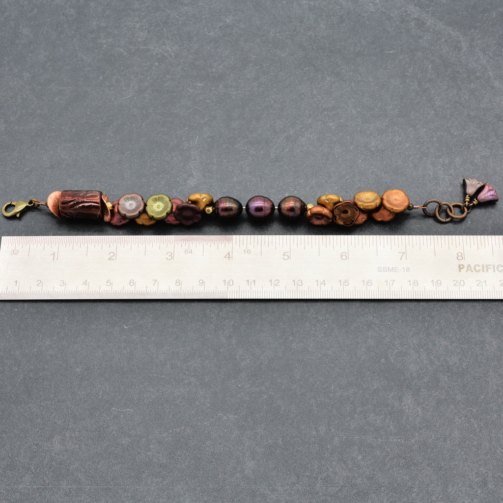 Beaded bracelet with a ruler for scale on a gray background