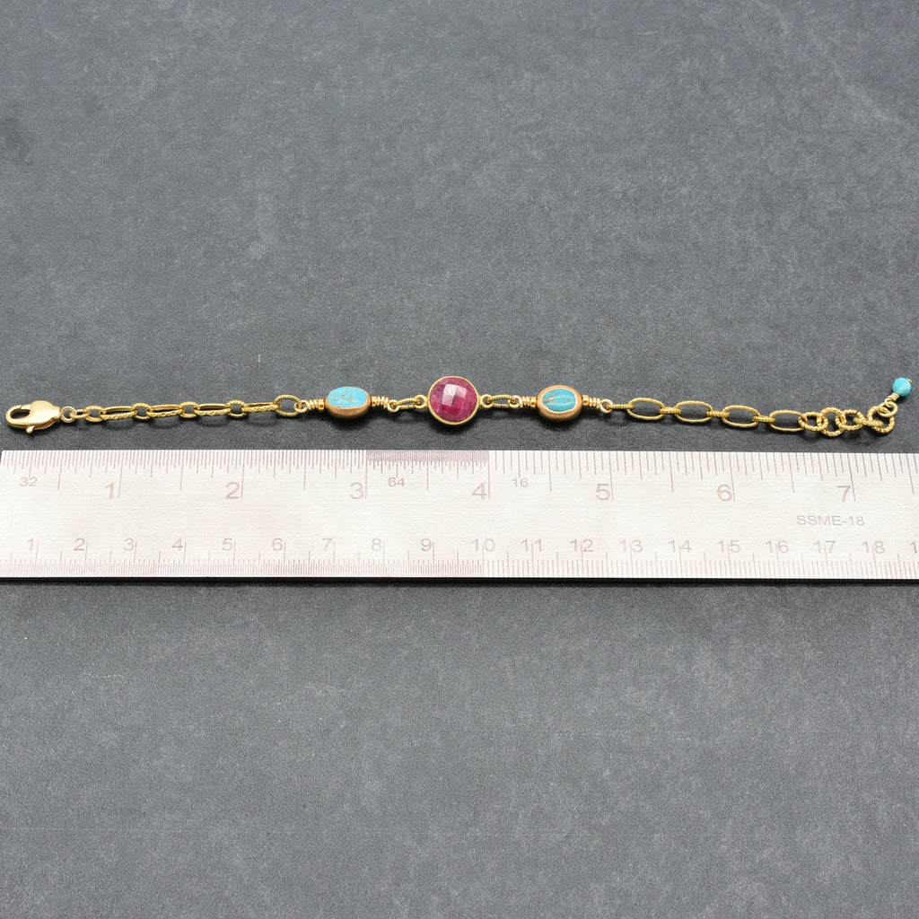Gold bracelet with colored beads on a gray surface with a ruler for scale - art you can wear by Ruby Acorn