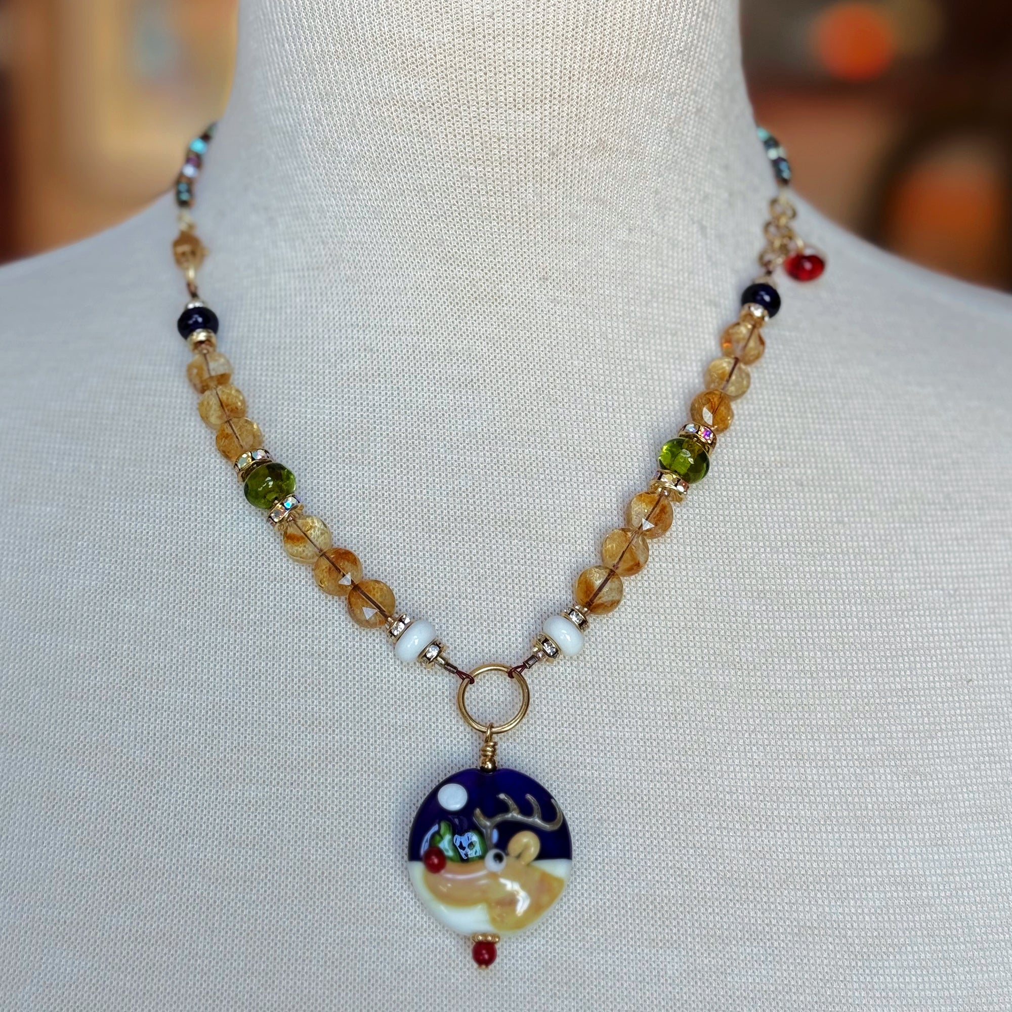 Necklace with a reindeer pendant on a mannequin