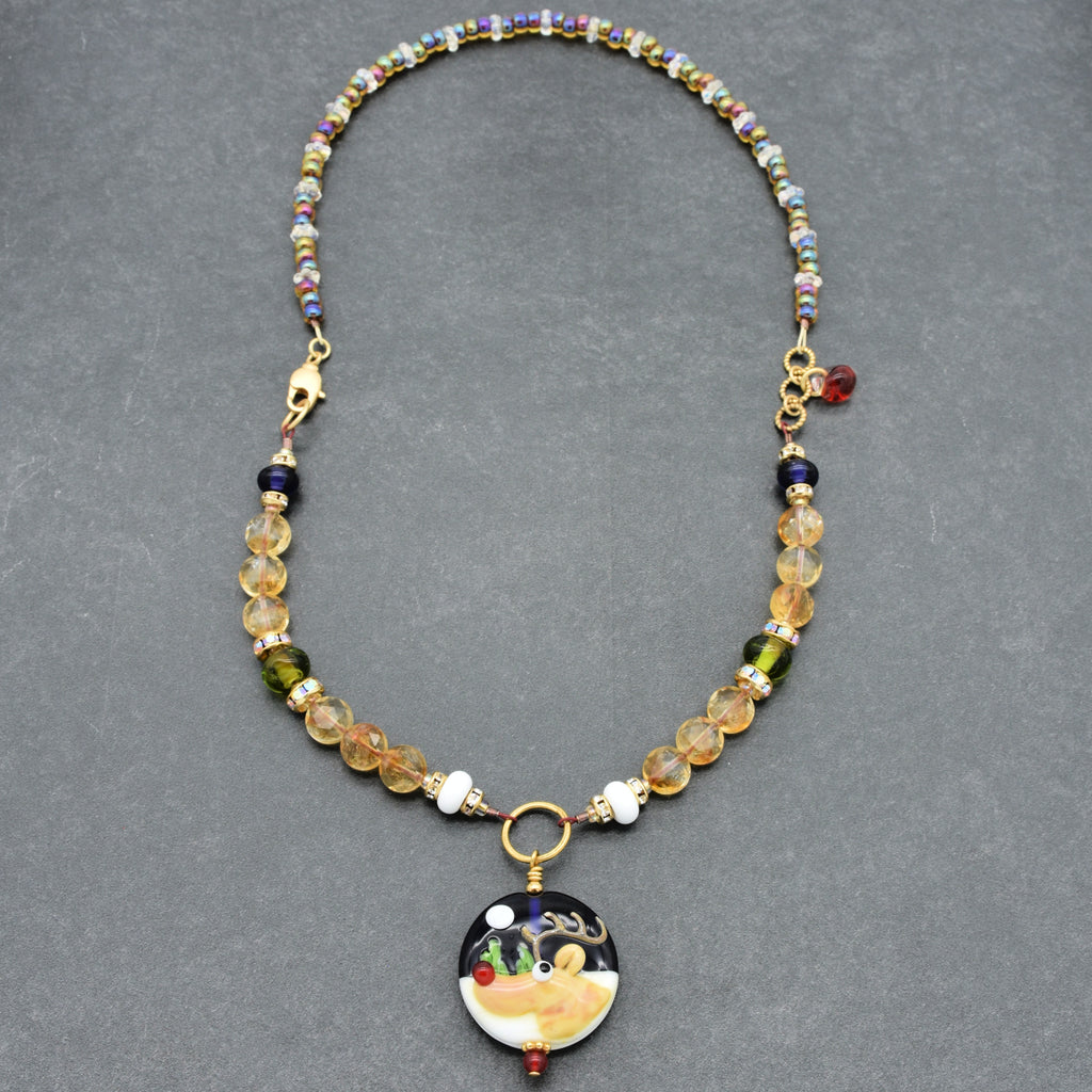 Necklace with colorful beads and a decorative reindeer pendant on a gray background