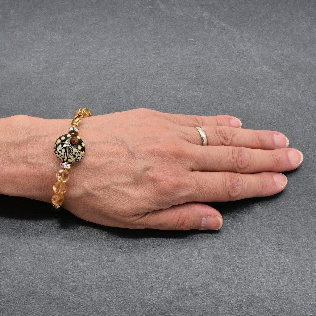 Solstice Luxe Bracelet featuring artisan lampwork glass focal with smoky quartz and citrine faceted coins, handmade by Ruby Acorn
