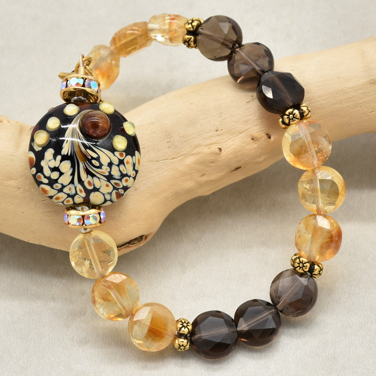 Solstice Luxe Bracelet featuring artisan lampwork glass focal with smoky quartz and citrine faceted coins, handmade by Ruby Acorn