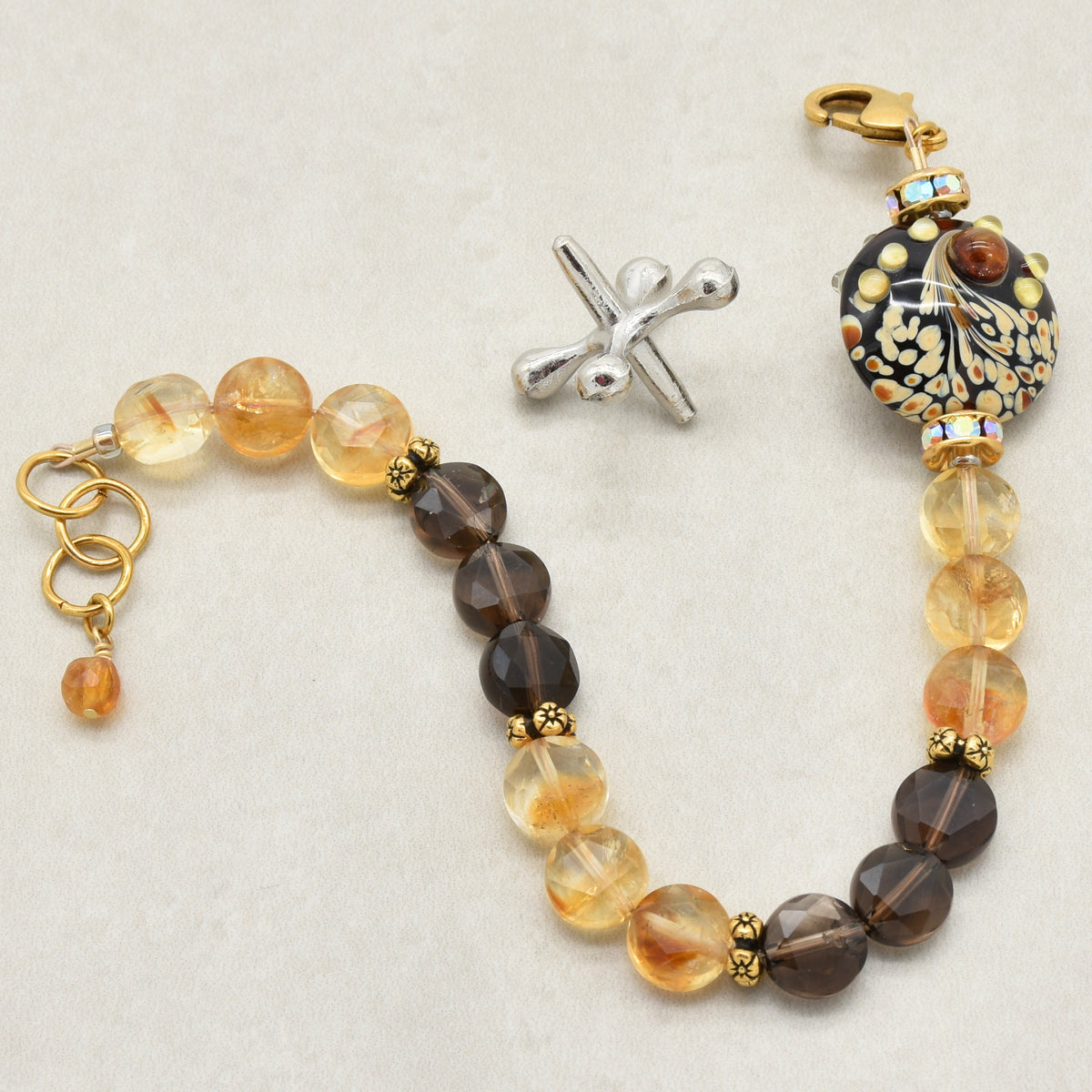 Solstice Luxe Bracelet featuring artisan lampwork glass focal with smoky quartz and citrine faceted coins, handmade by Ruby Acorn