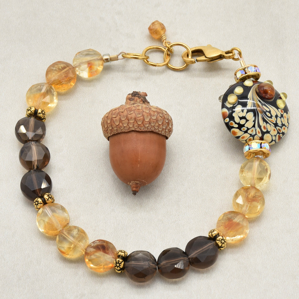 Solstice Luxe Bracelet featuring artisan lampwork glass focal with smoky quartz and citrine faceted coins, handmade by Ruby Acorn