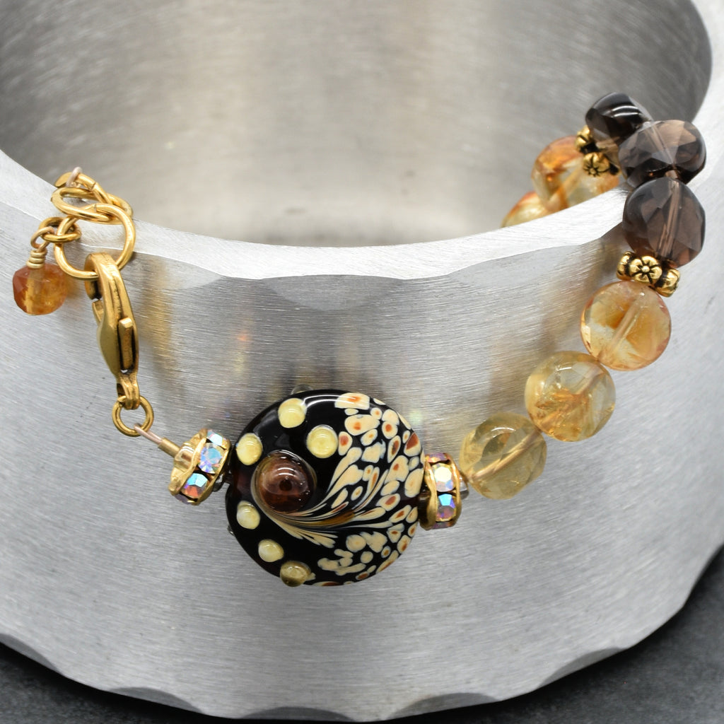 Solstice Luxe Bracelet featuring artisan lampwork glass focal with smoky quartz and citrine faceted coins, handmade by Ruby Acorn
