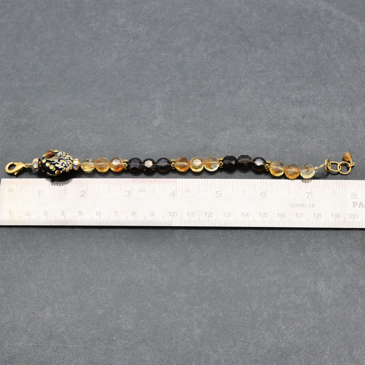 Solstice Luxe Bracelet featuring artisan lampwork glass focal with smoky quartz and citrine faceted coins, handmade by Ruby Acorn
