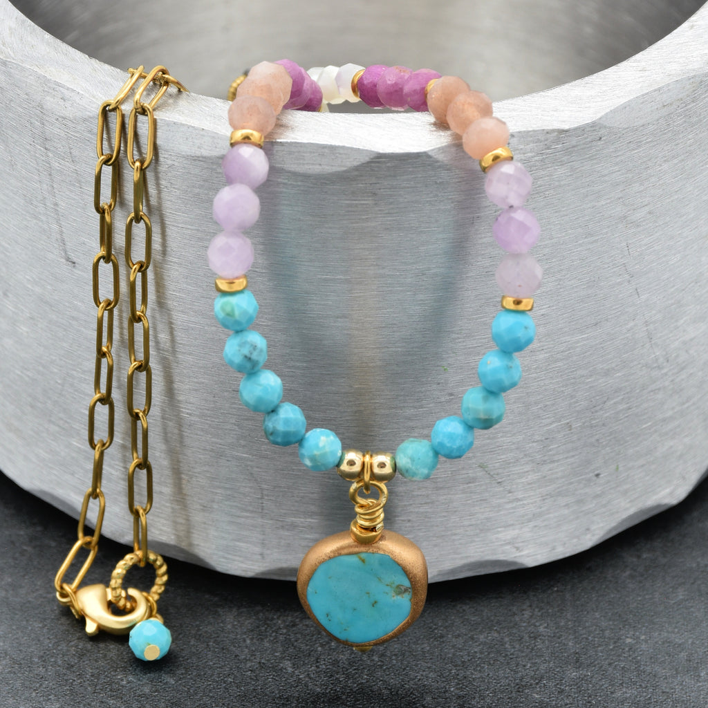 Close up of a multi gem gold chain choker necklace with genuine turquoise focal, kunzite, peach moonstone, and more on a silver background - made with love by Ruby Acorn