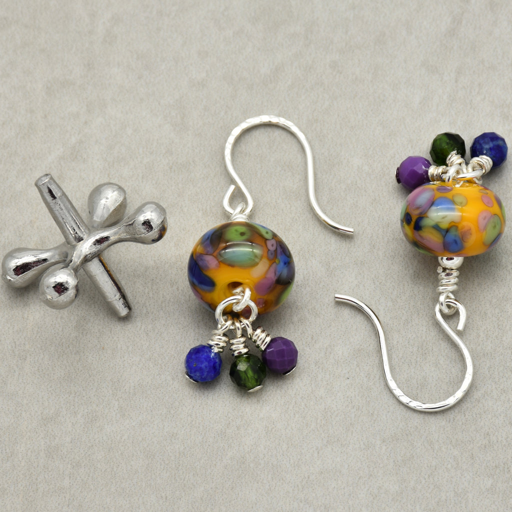 Colorful beaded earrings with silver hooks on a gray background