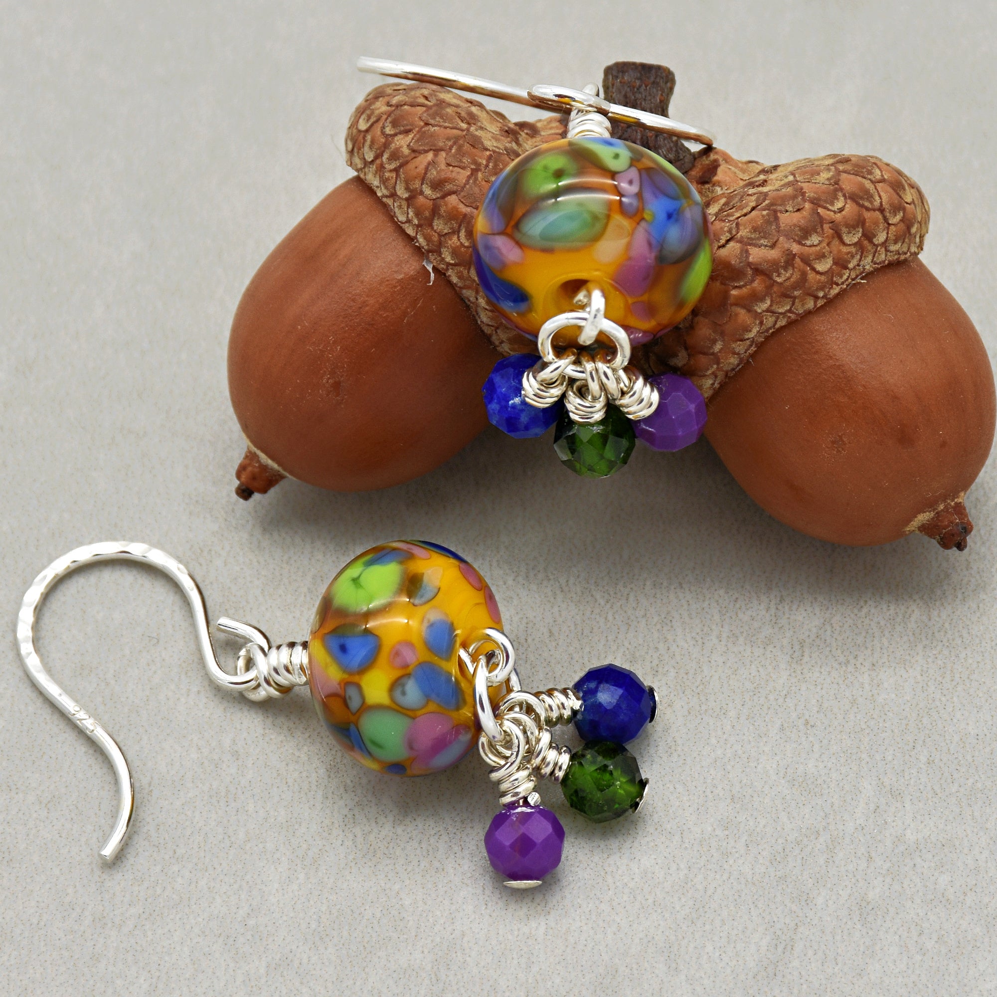 Colorful beaded earrings with silver hooks on acorns.