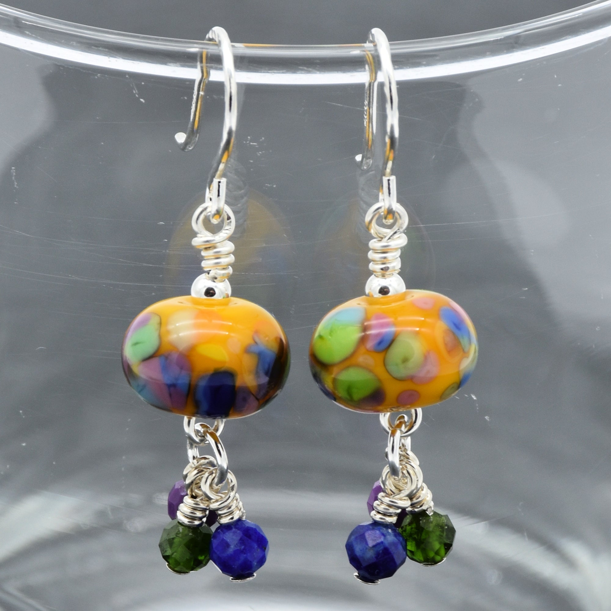Colorful beaded earrings on a clear stand