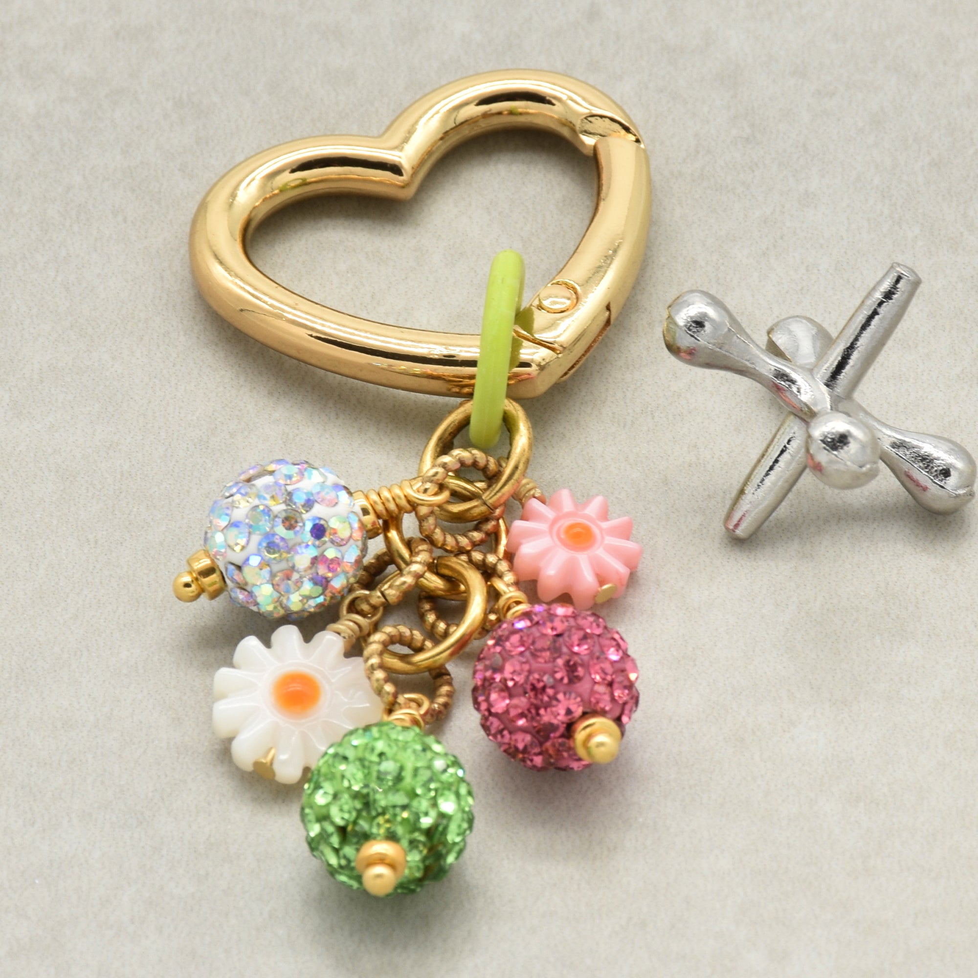 Decorative keychain with colorful charms on a beige background