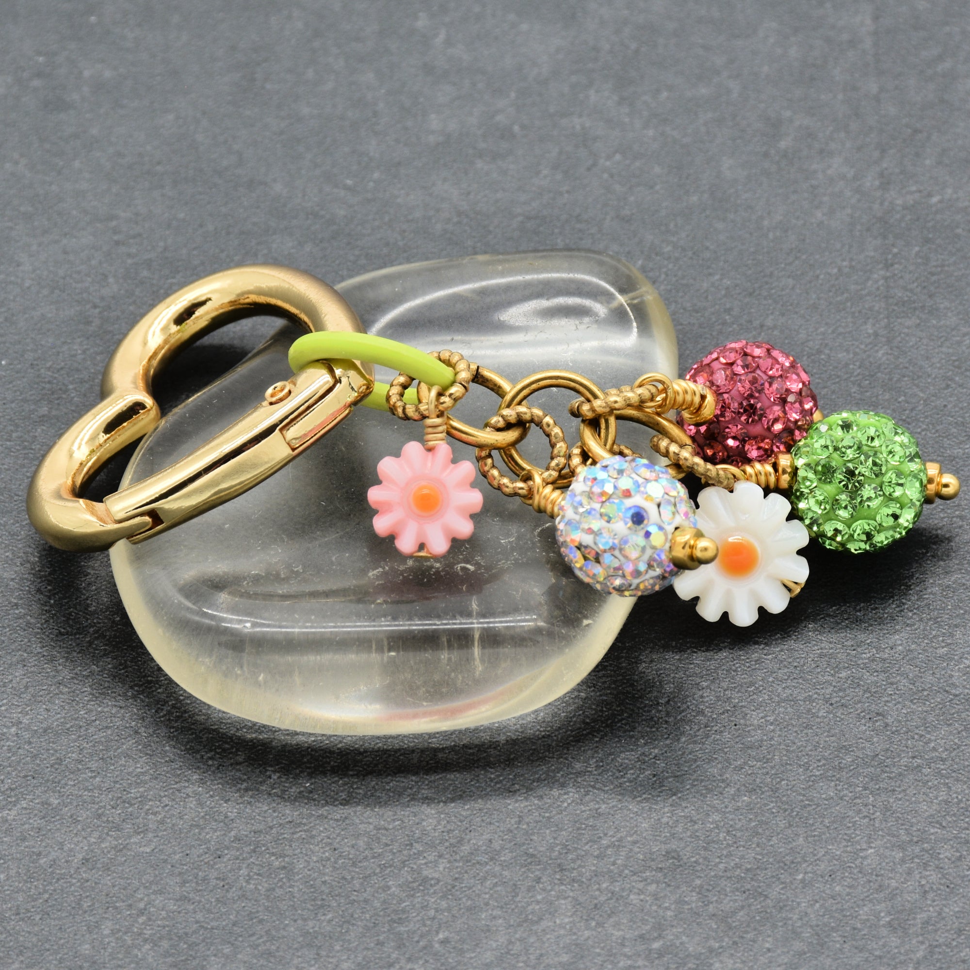 Decorative keychain with colorful charms on a gray background