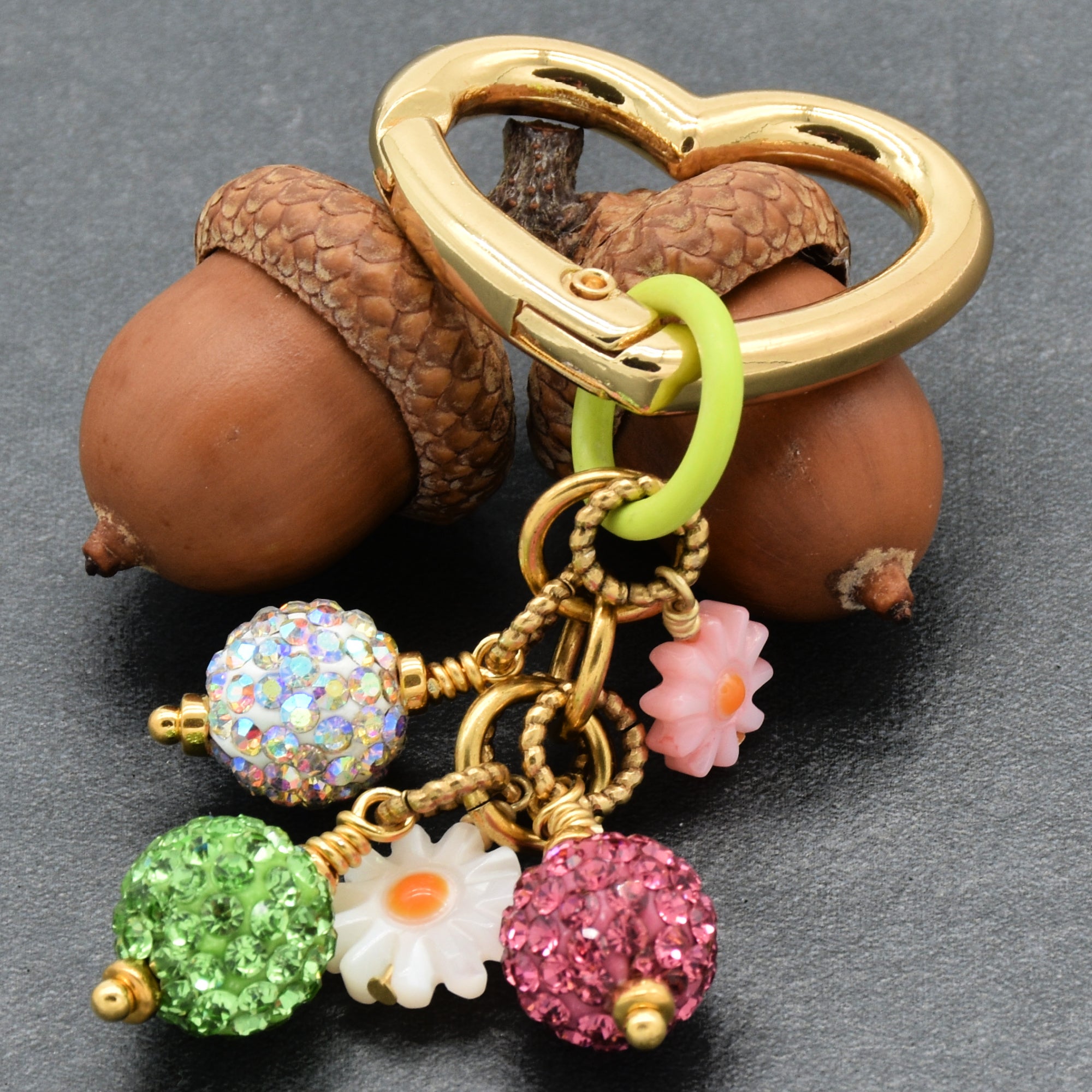 Keychain with heart-shaped clasp and colorful charms on a dark background