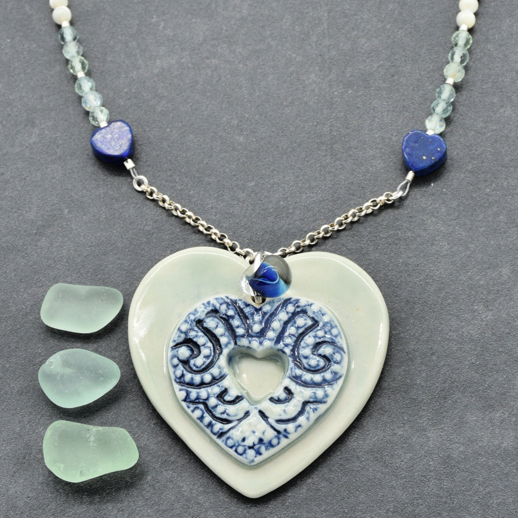 Necklace with a heart-shaped ceramic pendant on a gray background