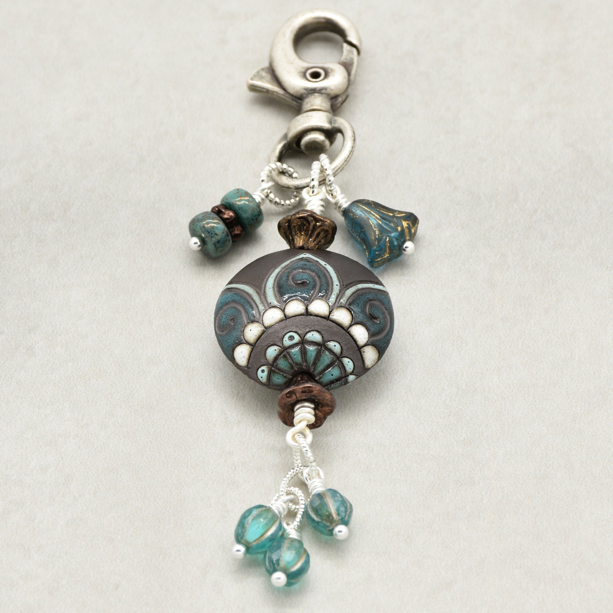Decorative keychain with beads and a clasp on a light gray background