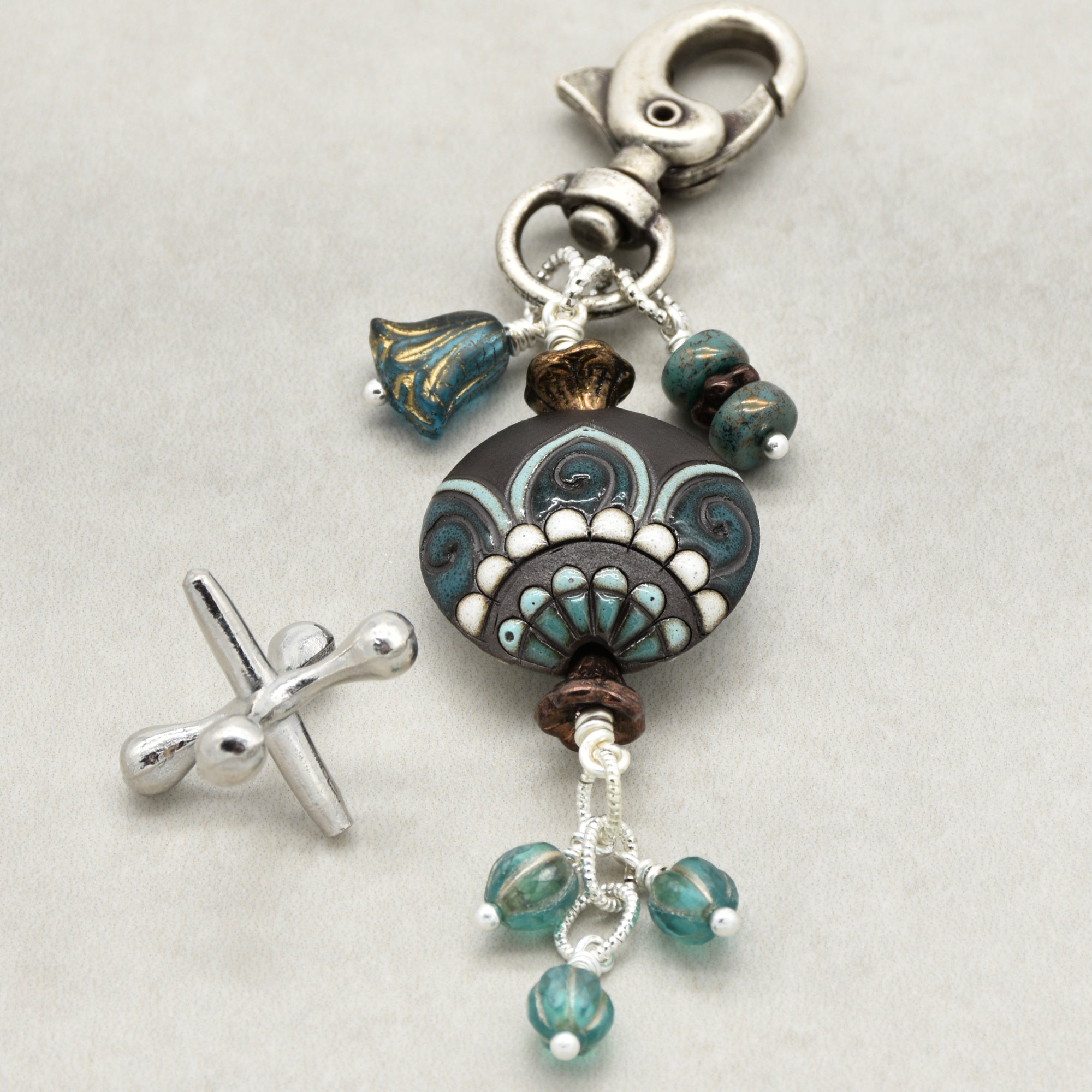 Decorative keychain with beads and charms on a light gray background