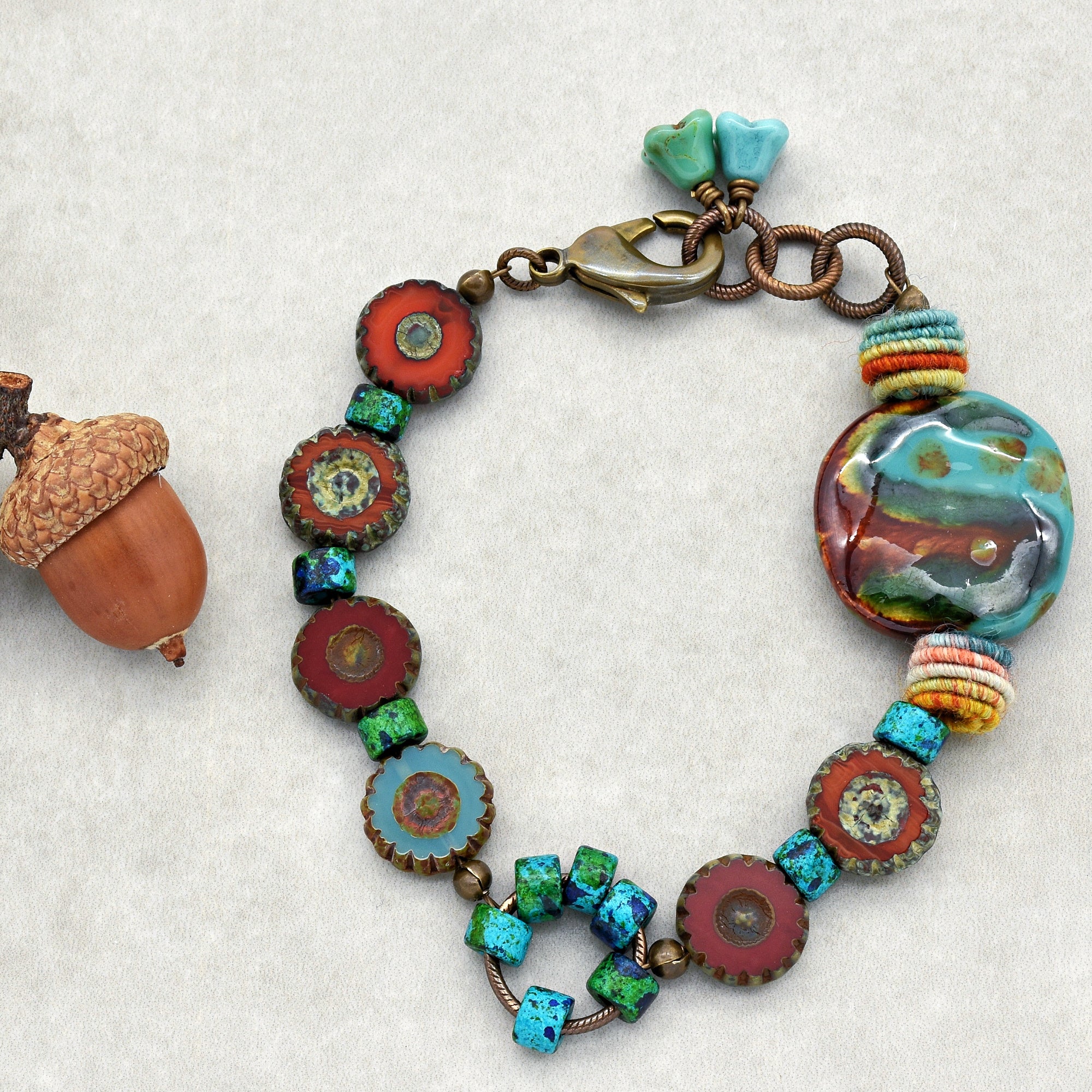 This image shows a bracelet. The jewelry piece is circular and relatively short in length, consistent with the size and shape of a bracelet. It has a clasp, beads, and a decorative round element, all features typical of a bracelet design.