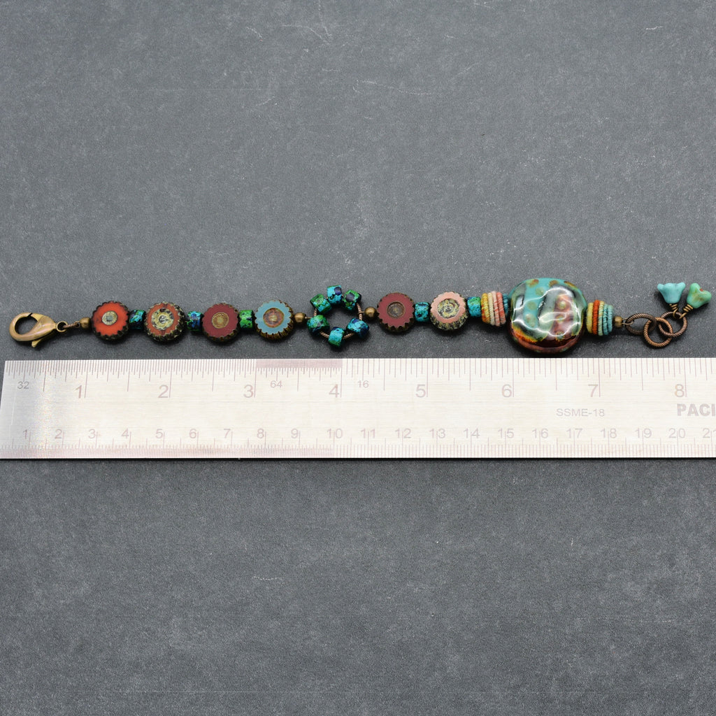 This image shows a bracelet. The size of the jewelry along with the clasp and arrangement of beads clearly indicate that it is designed to be worn around the wrist. The ruler also suggests the length is consistent with that of a bracelet.