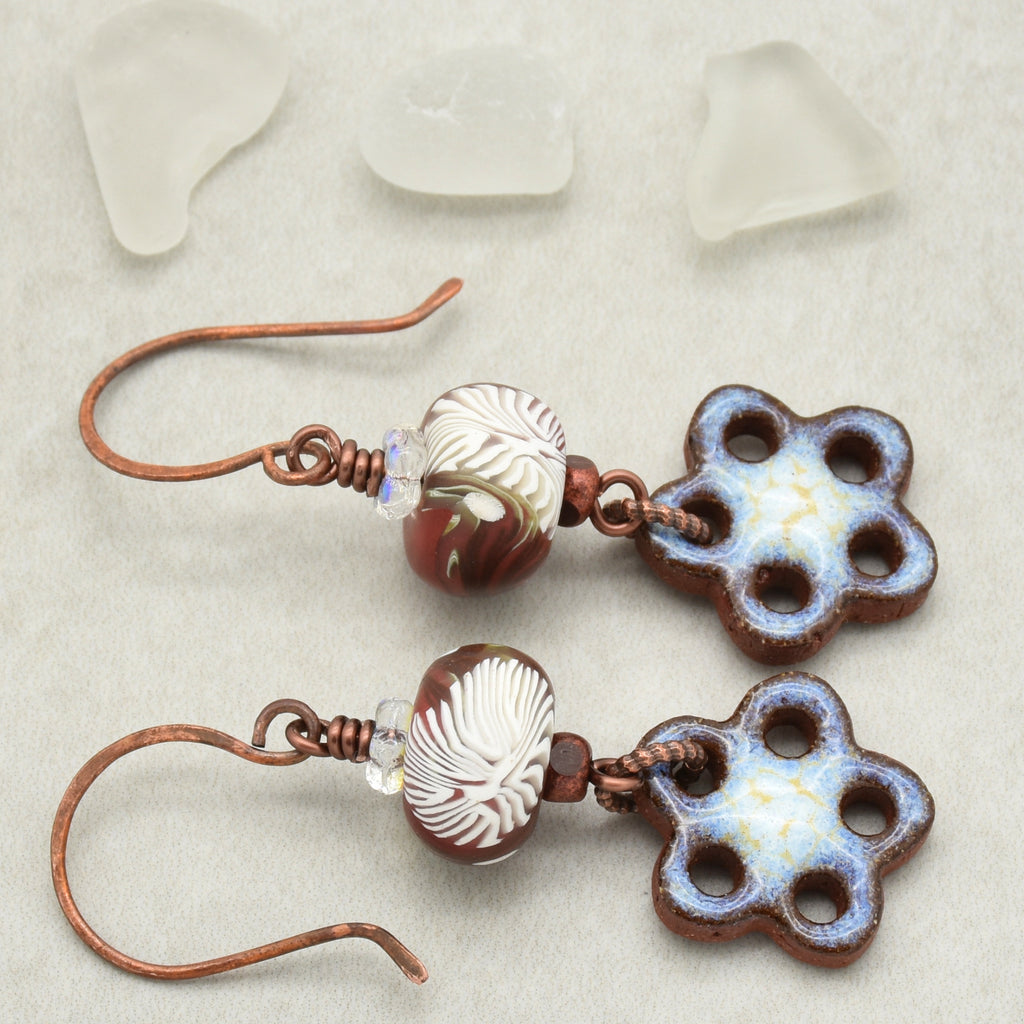 Pair of earrings with flower-shaped beads on a light background