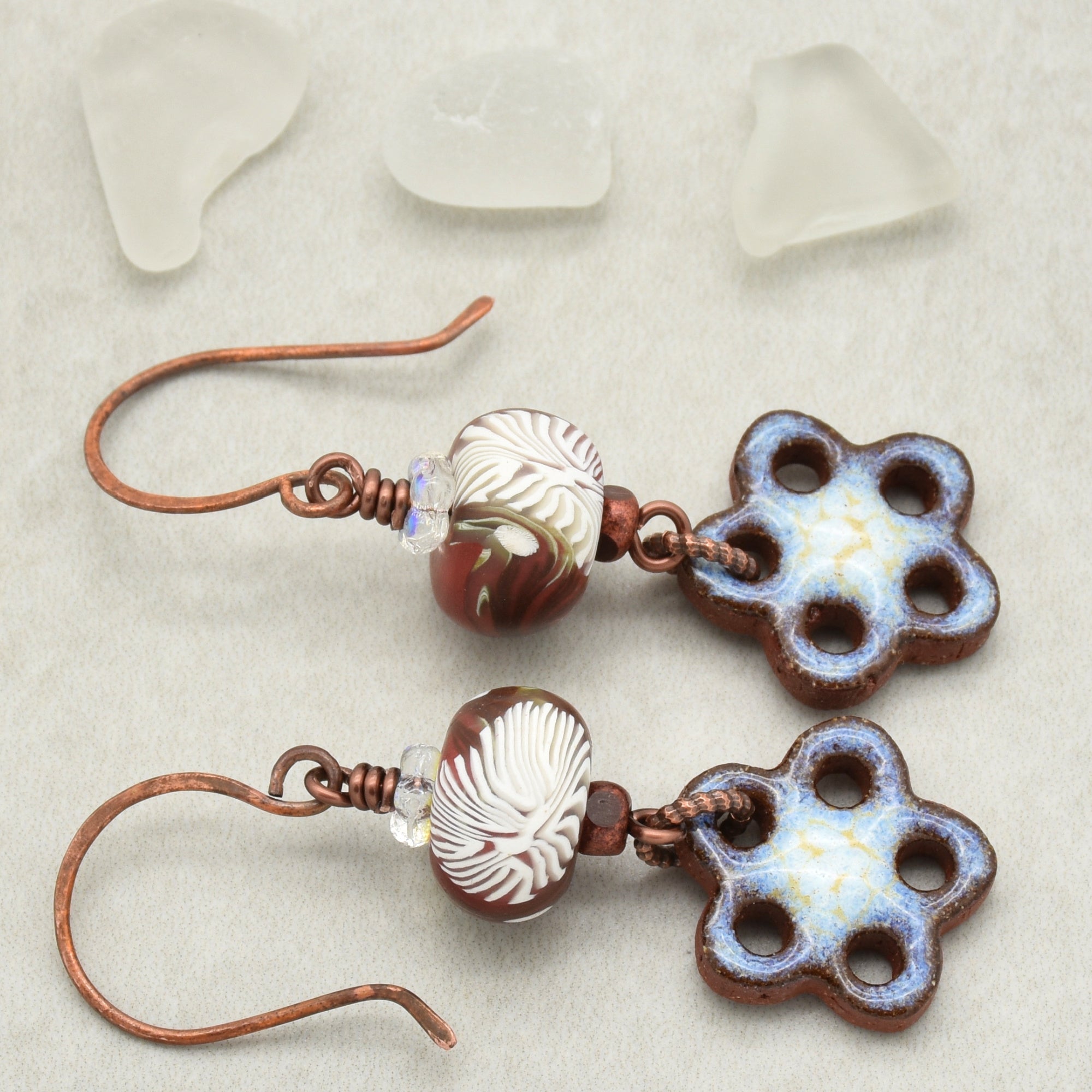 Pair of earrings with flower-shaped beads on a light background