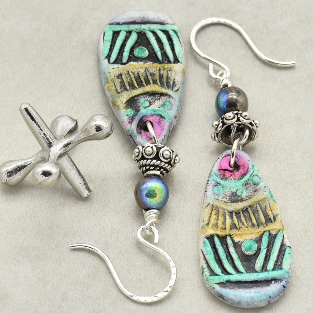 Colorful artisan polymer clay earrings with silver hooks on a light gray background
