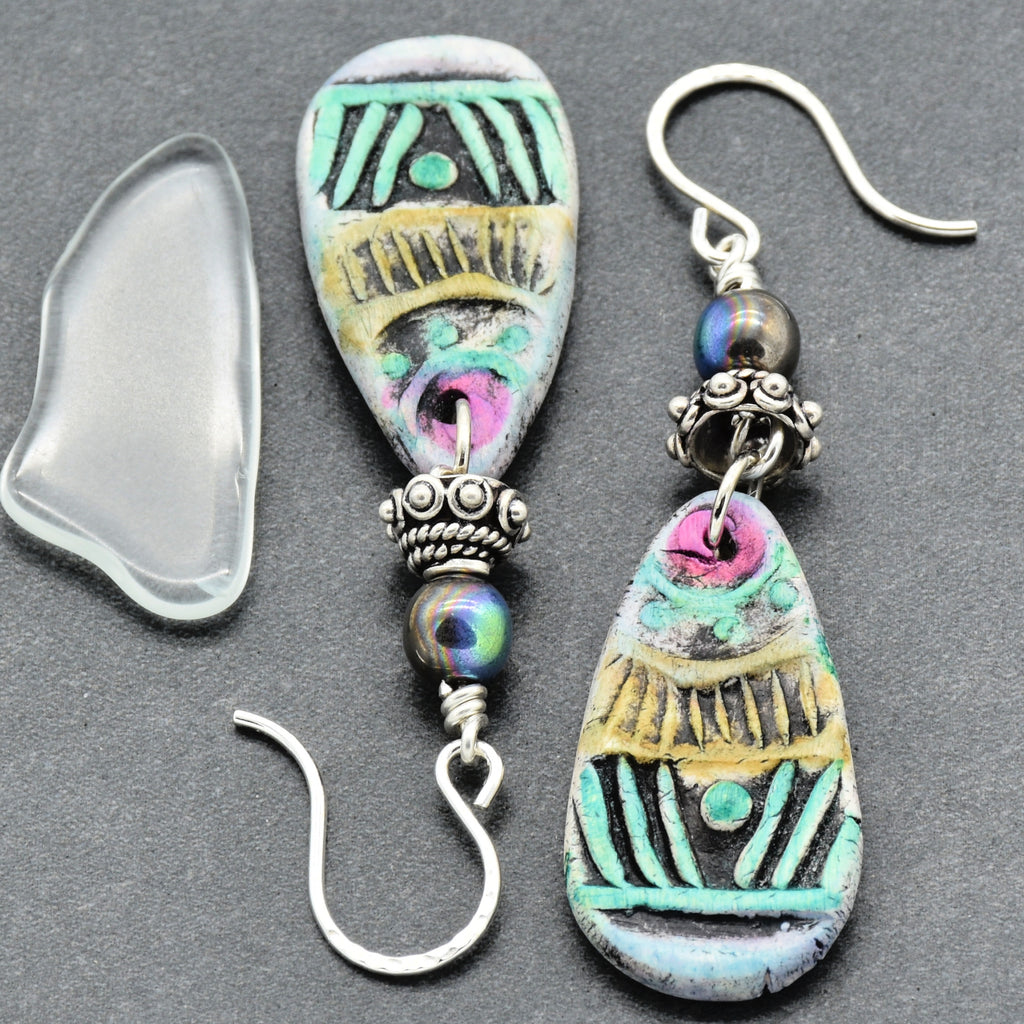 Colorful polymer clay earrings with silver hooks on a gray background
