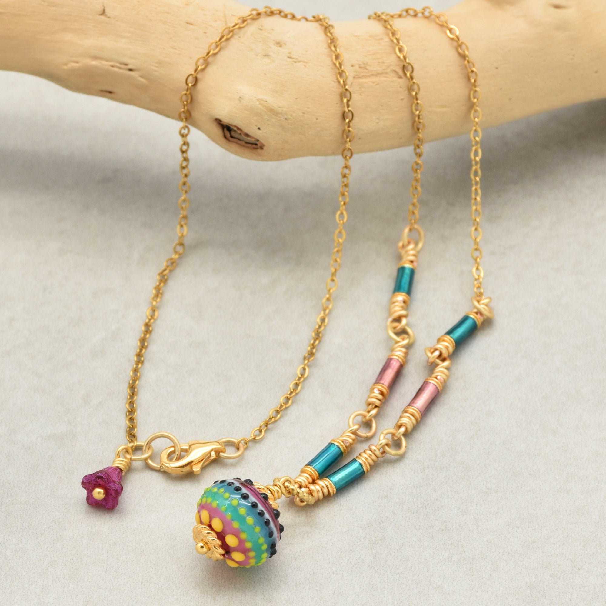 Gold chain necklace with colorful artisan lampwork glass focal and enamel tubes on a neutral background - handmade with love by Ruby Acorn