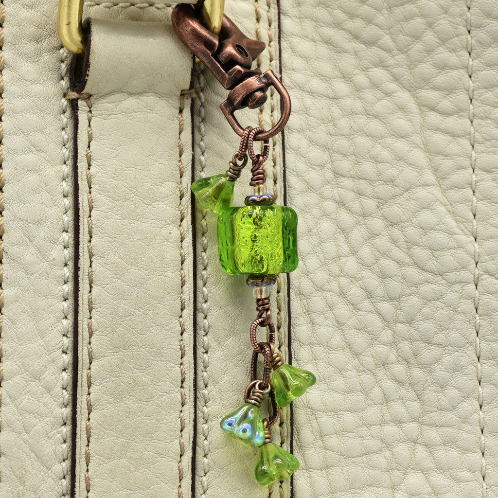 Close-up of a green beaded charm on a leather surface