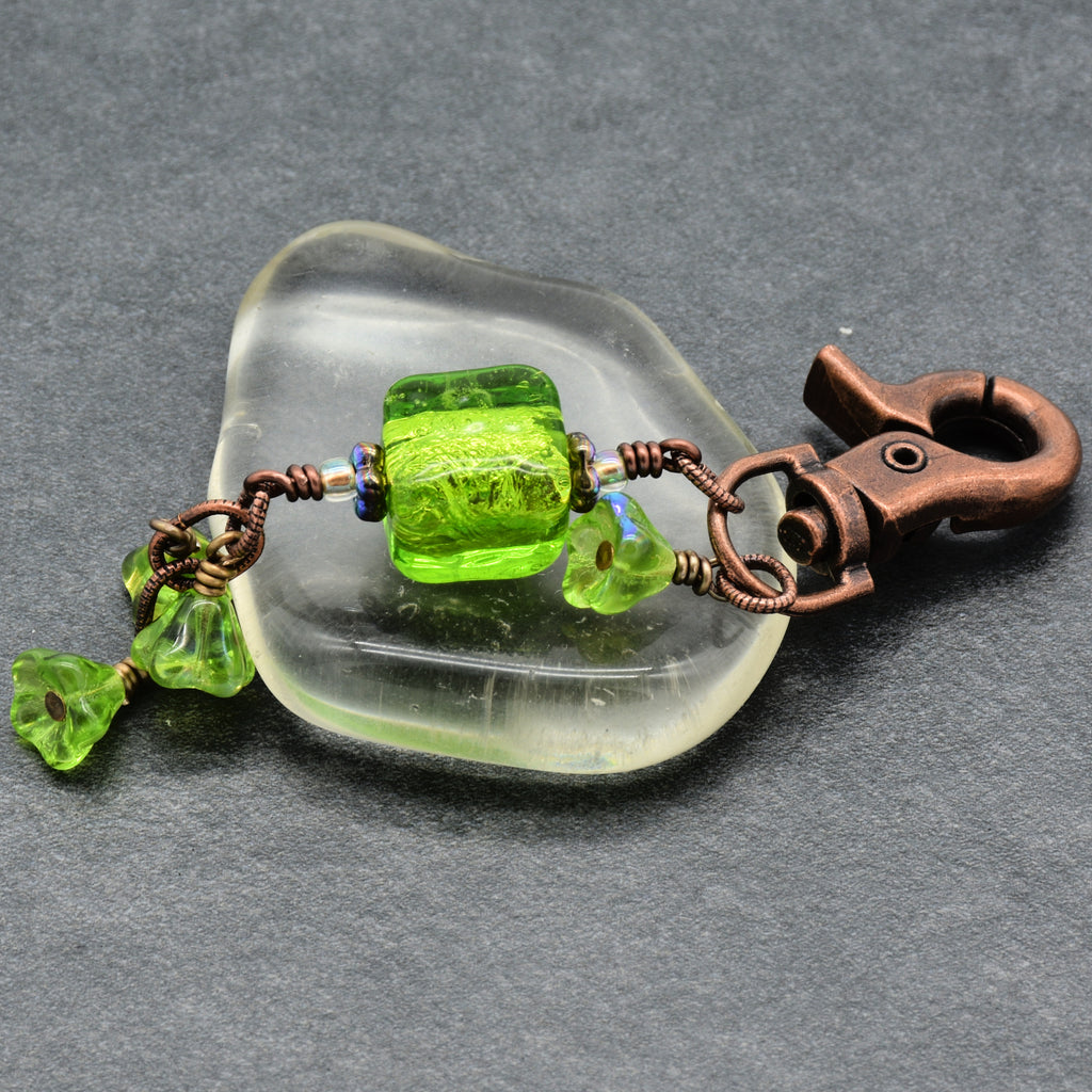 Keychain with green beads on a gray background