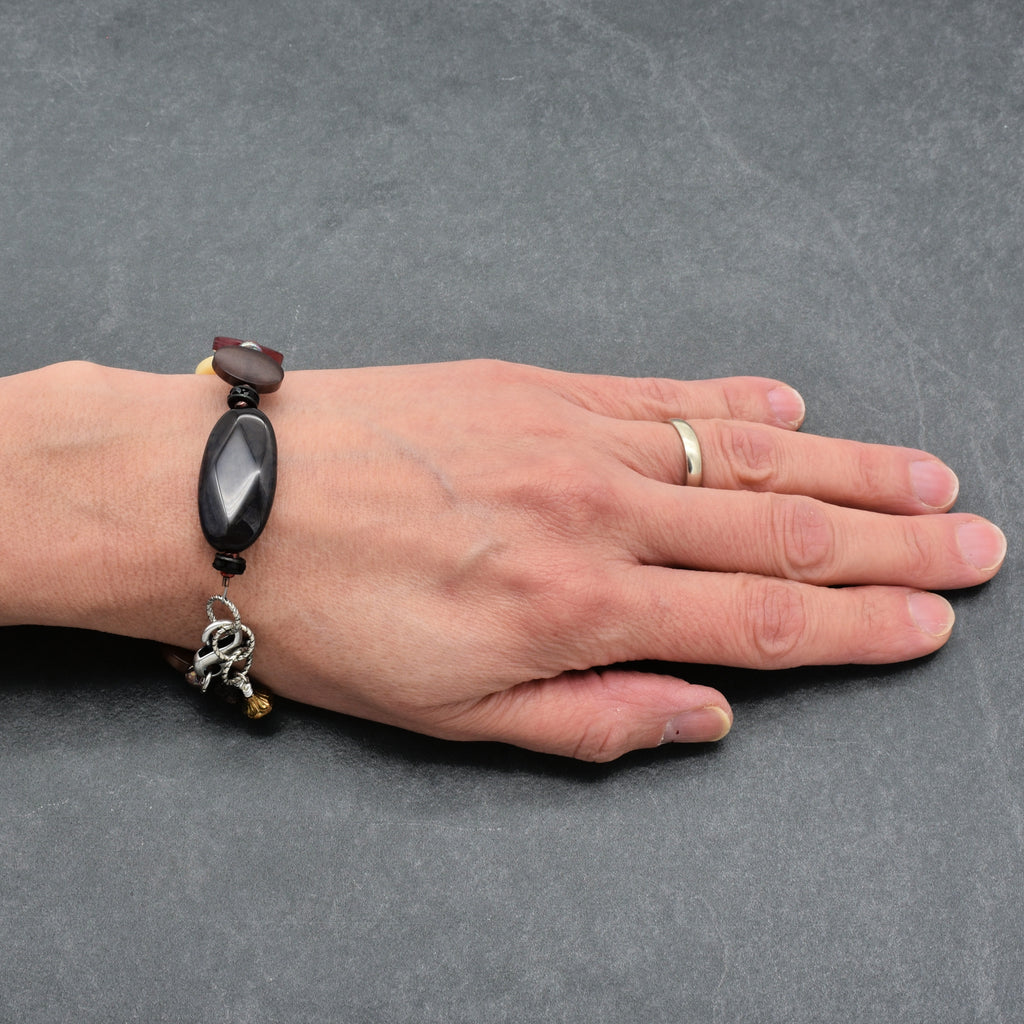 Hand wearing a bracelet on a gray background