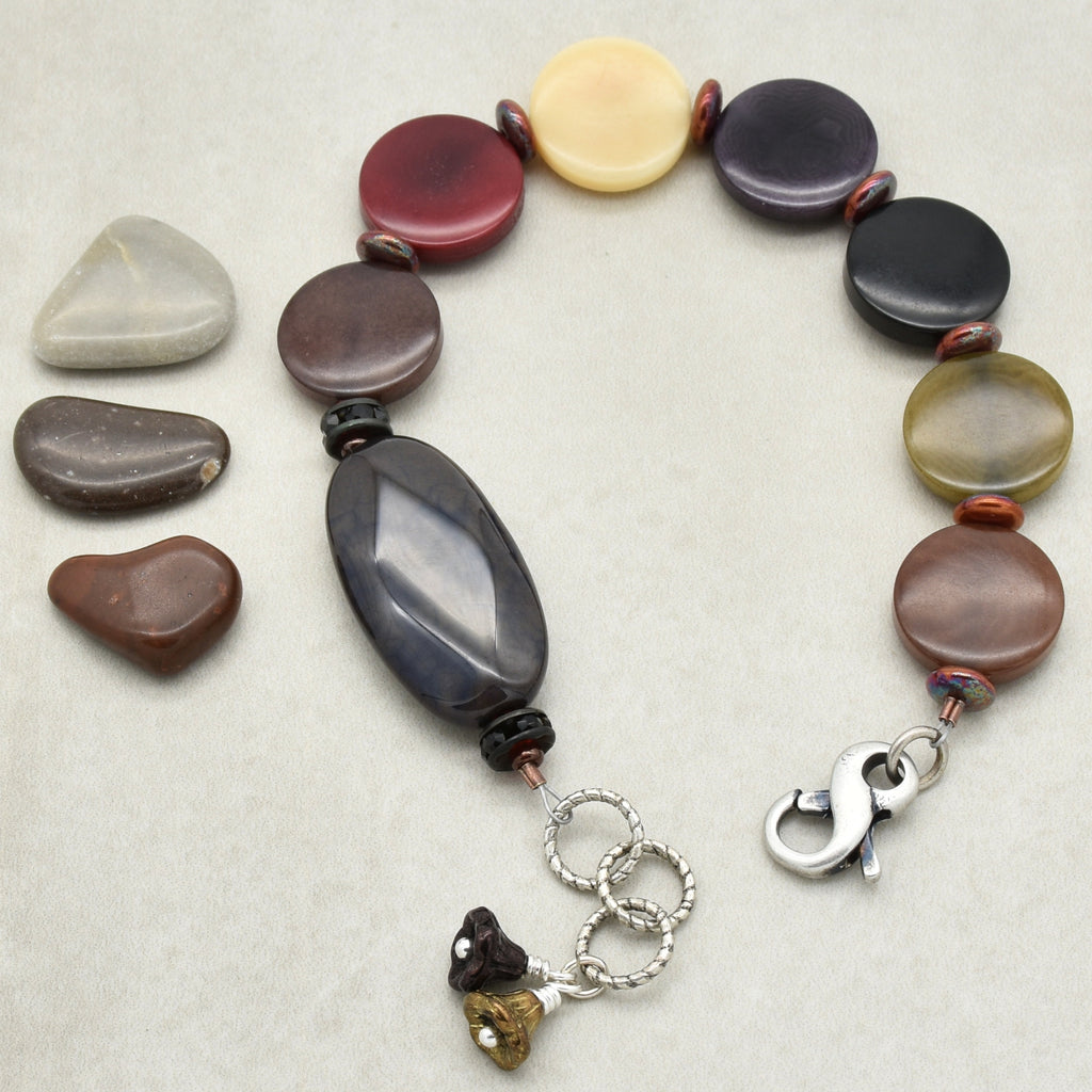 Bracelet with multicolored beads and a silver clasp on a light gray background