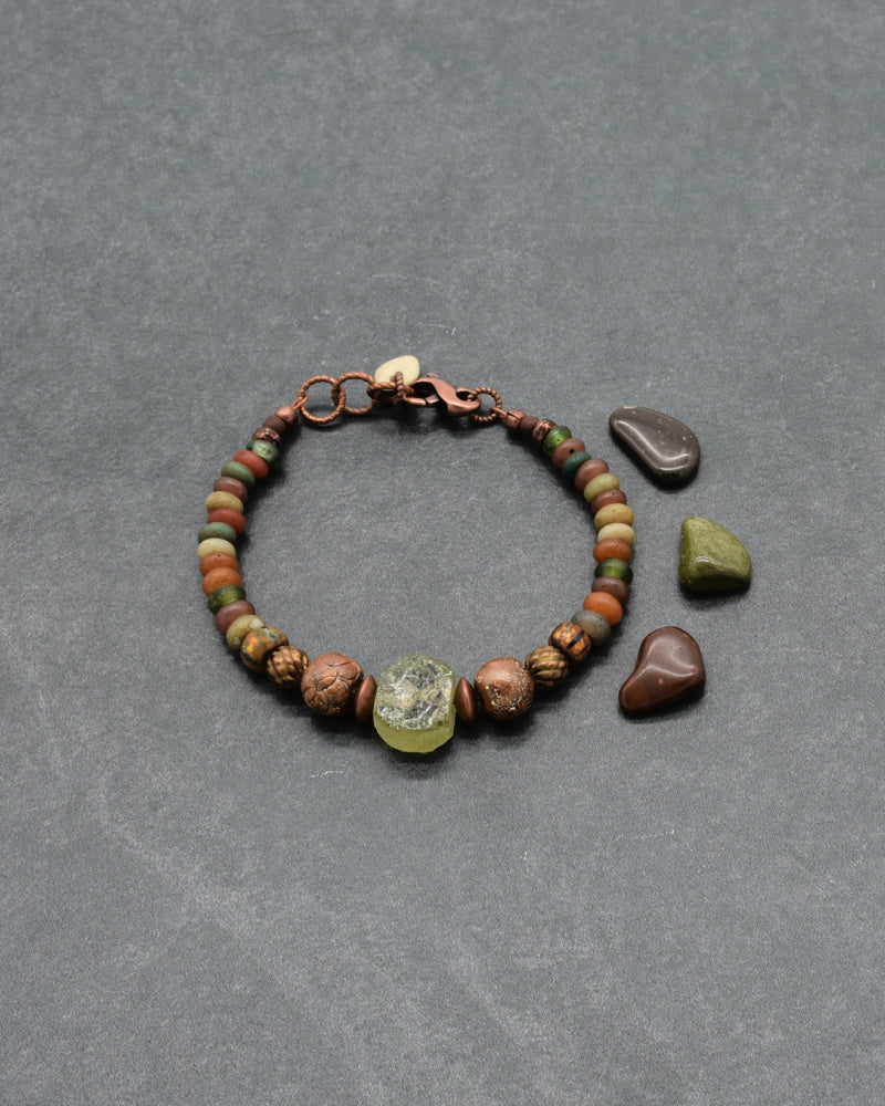 Handmade beaded bracelet with ancient Roman glass focal, Indonesian glass rondelles in terracotta, green and ochre with ancient copper accents - made with love by Ruby Acorn.