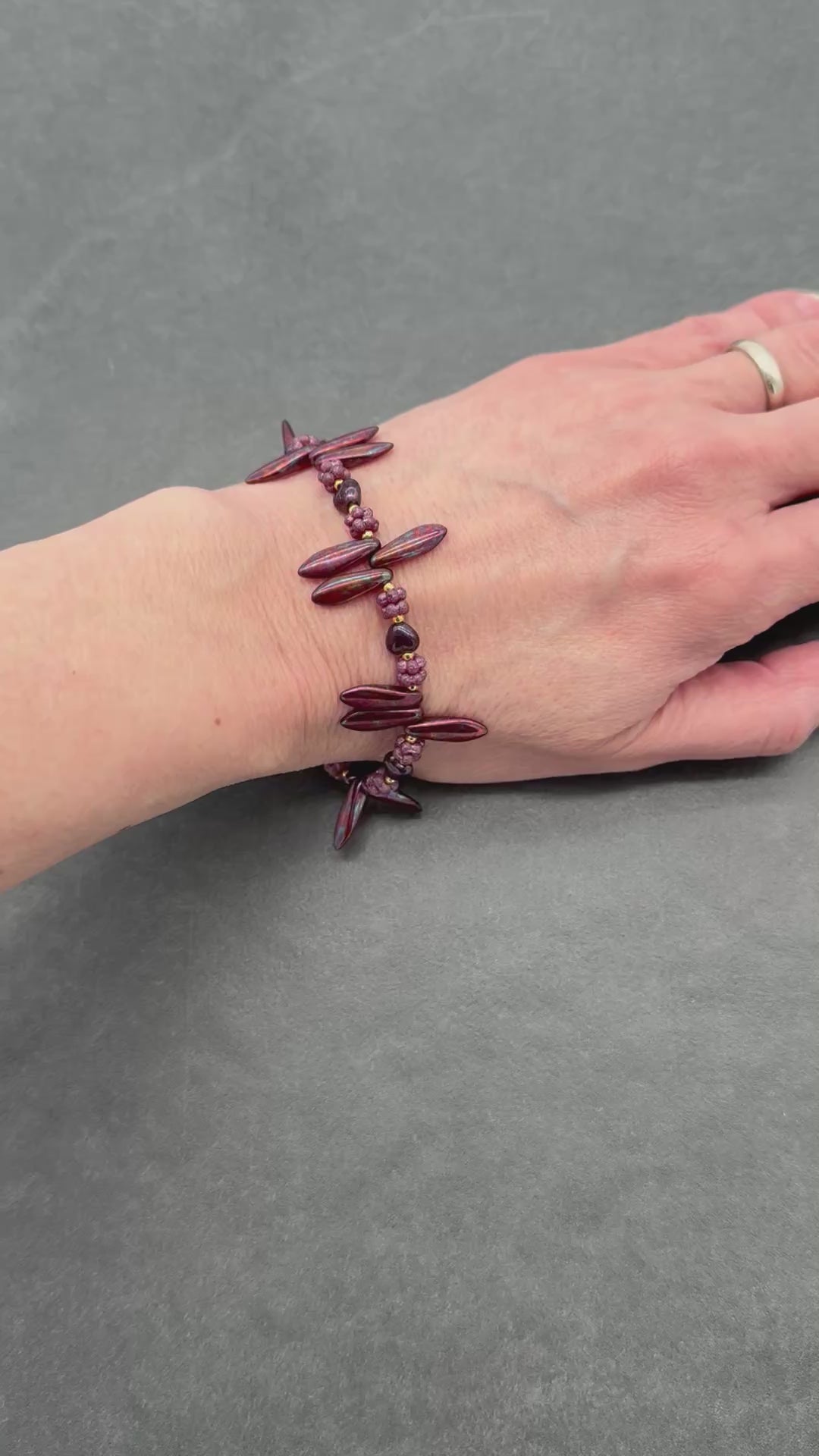 video of hand wearing burgundy beaded bracelet.