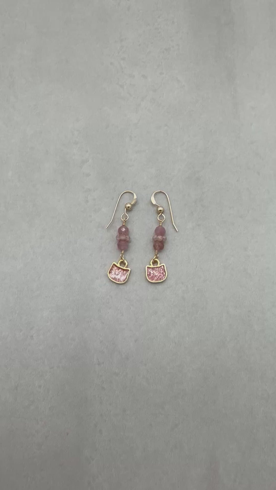Video of lovely delicate pink dangle earrings with cat charms, pink tourmaline, and gold ear wires on a light background - handmade with love by Ruby Acorn