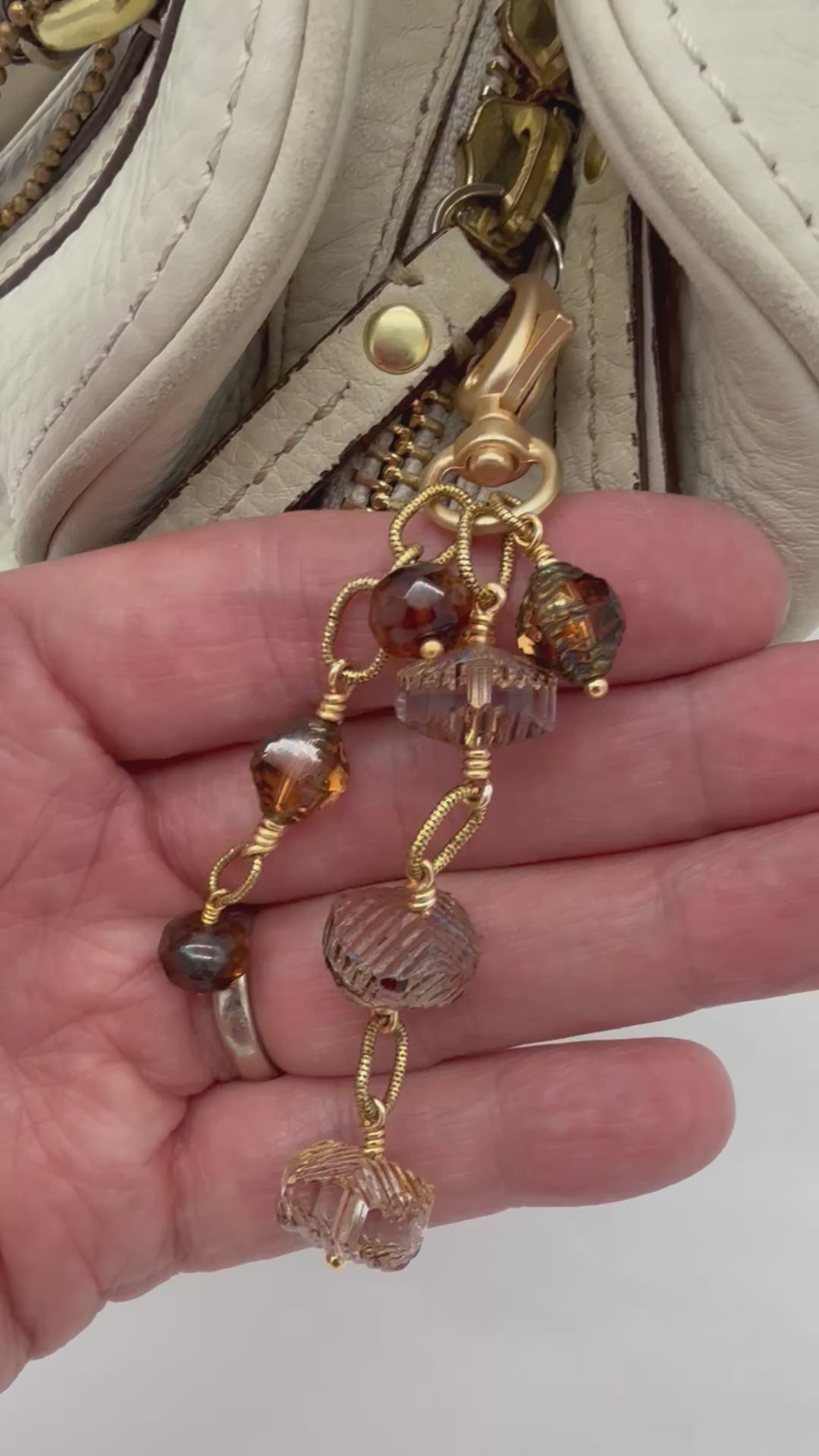 Video of Smoky Reverie Handbag Charm featuring wire-wrapped etched Czech glass rondelles in smoky topaz with gold lobster claw, handmade by Ruby Acorn